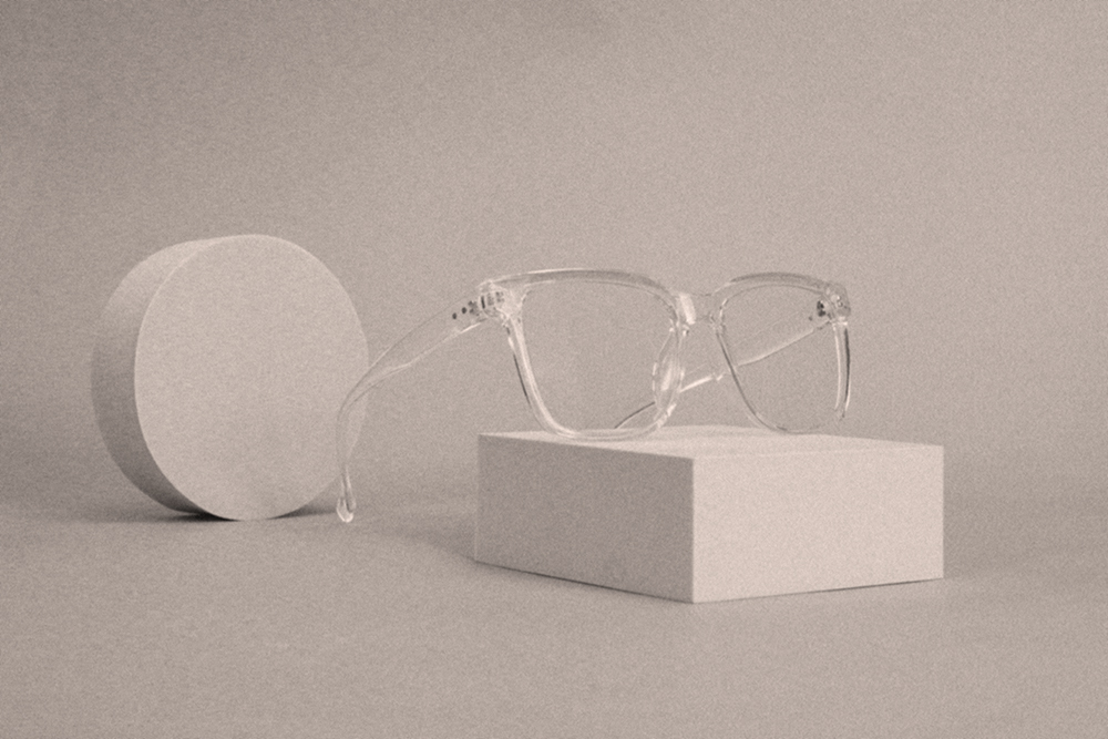 Minimalist product styling with clear eyeglasses on geometric blocks, symbolising clarity and vision in branding.