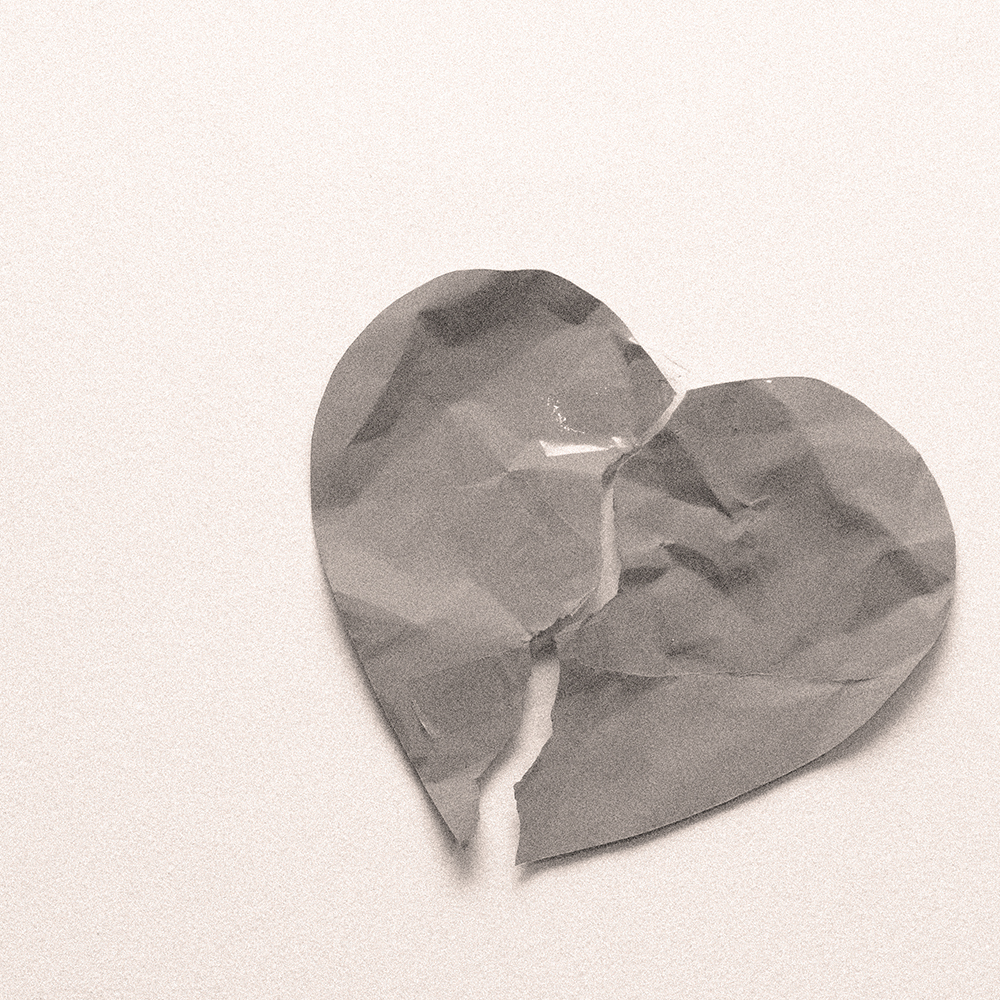 Abstract paper heart split into uneven pieces on a neutral background, symbolising a disconnected or inconsistent brand identity.
