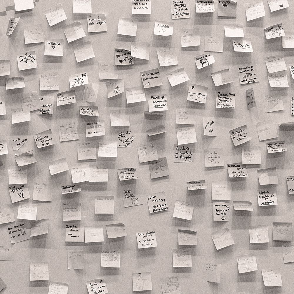 A wall filled with post it notes to symbolise brainstorming of ideas and strategy but feeling overwhelmed with information overload.